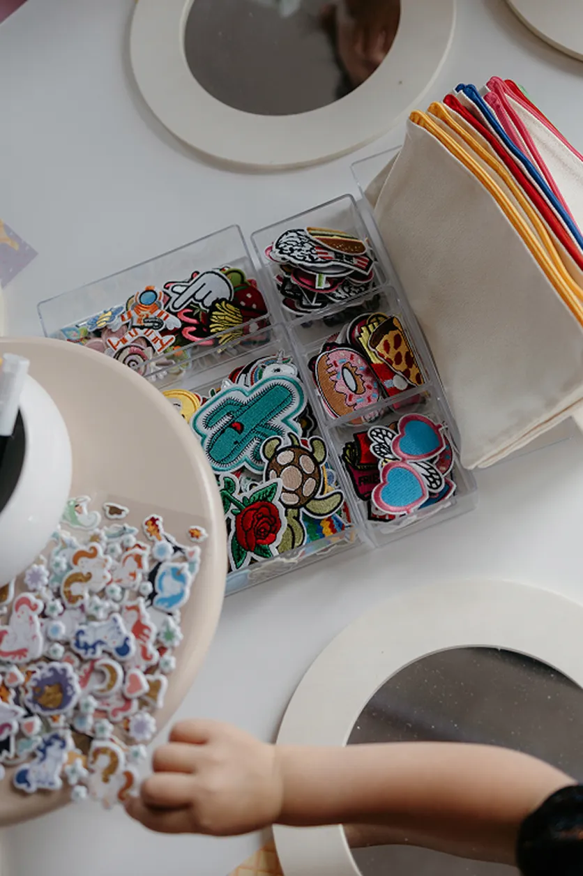 atelier-creatif-enfants-personnalisation-accessoires-yma-converti-depuis-jpg Atelier créatif pour enfants avec écussons brodés, autocollants colorés et pochettes en tissu à personnaliser.