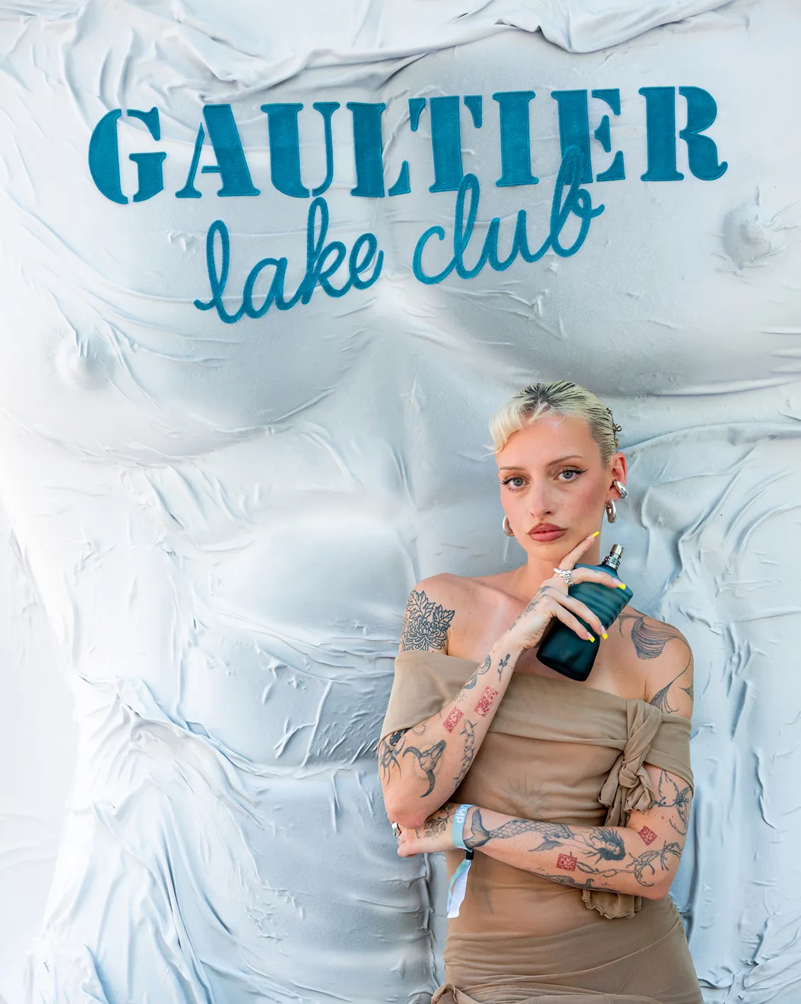 jean-paul-gaultier-lake-club-decor-evenementiel-converti-depuis-jpg Décor événementiel Gaultier Lake Club avec fond blanc texturé, lettrage bleu et présentation d’un parfum Jean Paul Gaultier.